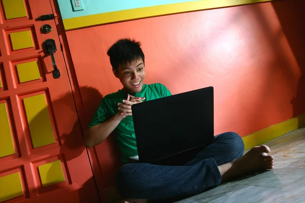 リビング ルームでラップトップ コンピューターを持つ若いアジアの 10 代 — ストック写真