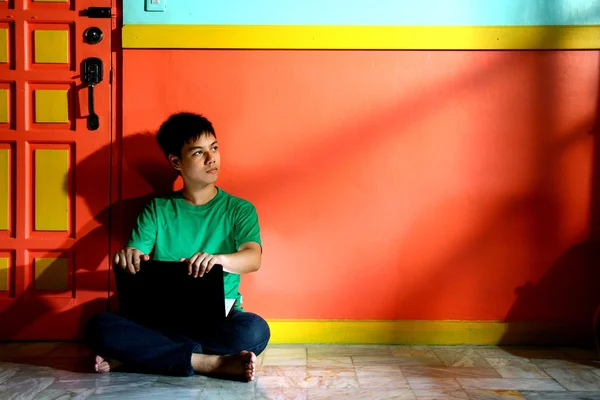 Young asian teen with a laptop computer in a living room — Stock Photo, Image