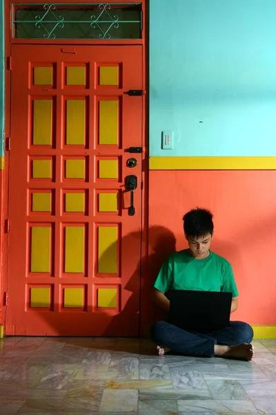 リビング ルームでラップトップ コンピューターを持つ若いアジアの 10 代 — ストック写真
