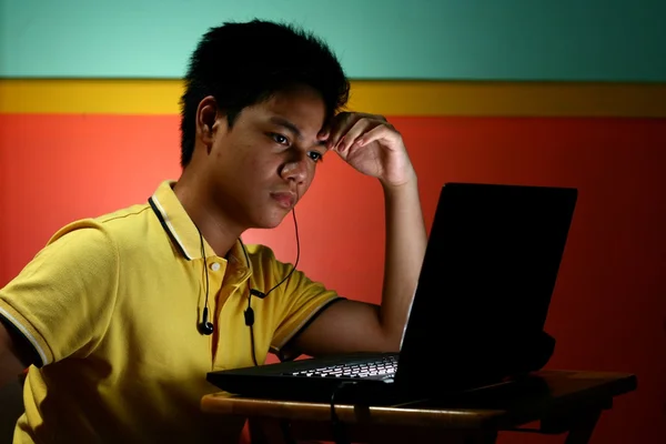 Asiática adolescente jugando o trabajando en un ordenador portátil — Foto de Stock