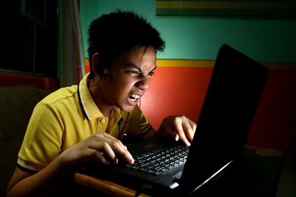 Asiatische Teenager spielen oder arbeiten auf einem Laptop-Computer — Stockfoto