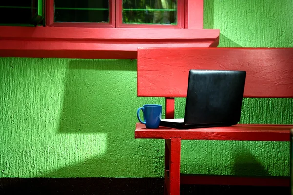 Laptop a kávu Hrnek na dřevěnou lavici — Stock fotografie