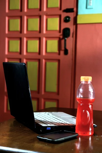 Computadora portátil, bebida energética embotellada y Smartphone —  Fotos de Stock