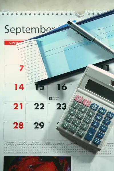 Calendario, chequera, calculadora, dinero y un bolígrafo — Foto de Stock