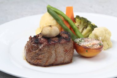 Taze pişmiş sığır fileto bifteği ya da sebze ve patates püresi ile servis edilen fileminyon..