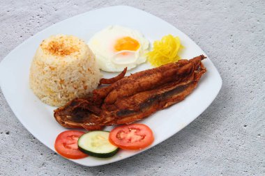 Bangsilog, Bangus veya Milkfish adlı taze pişmiş Filipinli yemeğin fotoğrafı. Yumurta ve kızarmış pirinçle servis ediliyor..