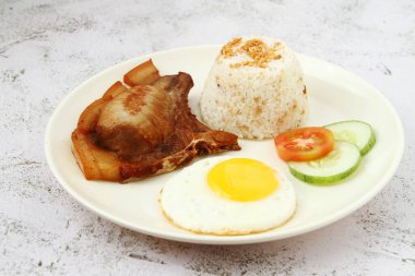 Photo of freshly cooked Filipino food called Pork Chop Silog or pork chop, egg and fried rice.