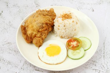 Photo of freshly cooked Filipino food called Chicksilog or fried chicken, egg and fried rice.