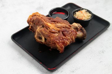 Photo of freshly cooked Filipino food called Crispy Pata or crispy deep fried pork leg.