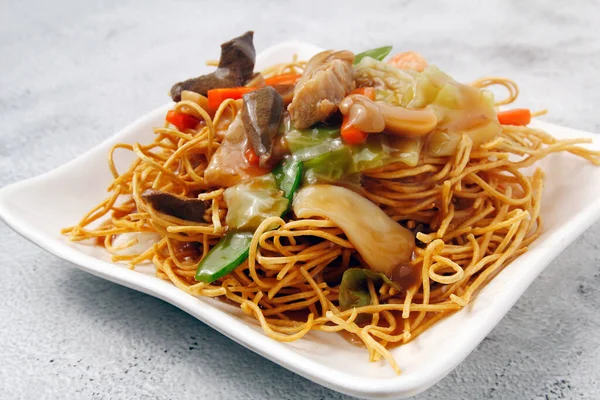 Photo of freshly cooked Chinese food called crispy noodles with meat and vegetables.