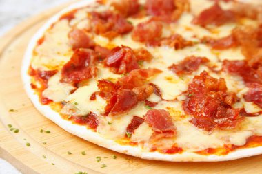 Photo of freshly cooked cheesy bacon pizza.