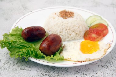 Photo of freshly cooked Filipino food called Longsilog or longganisa or sausage served with fried rice and egg