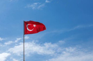 Mavi gökyüzünde dalgalanan Türk bayrağı.