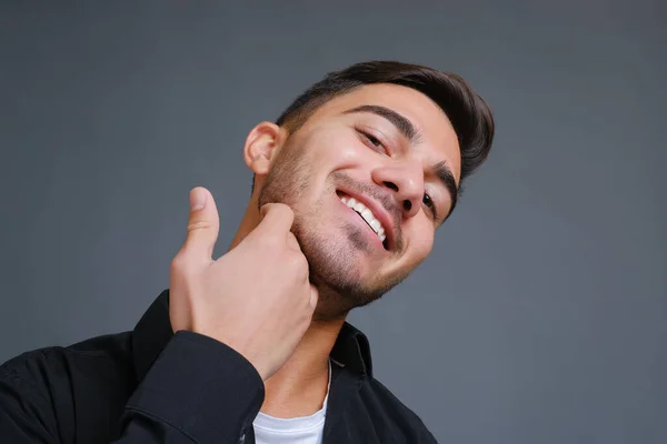 Sorrindo cara bonito tocando queixo raspado — Fotografia de Stock