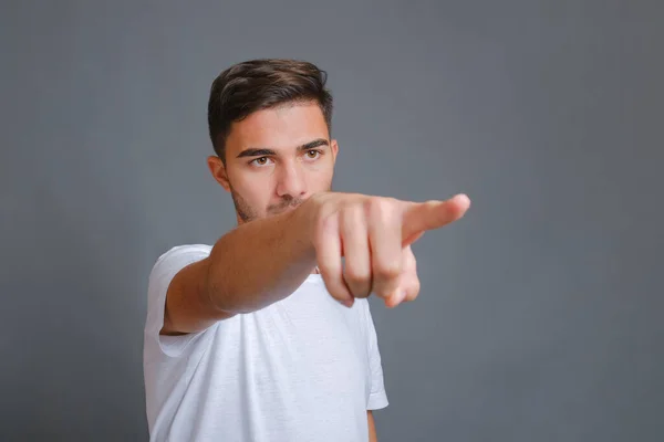 Homem de t-shirt branca mostra seu dedo indicador para a câmera — Fotografia de Stock