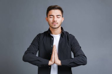 Erkekler el ele tutuşup meditasyon yaparlar.