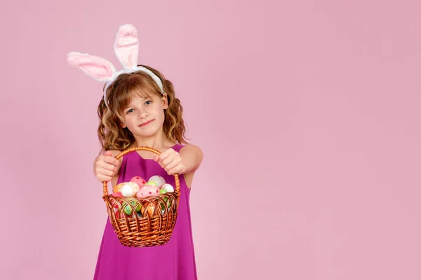 Niño feliz mostrando cesta con huevos decorados durante la celebración de Pascua —  Fotos de Stock