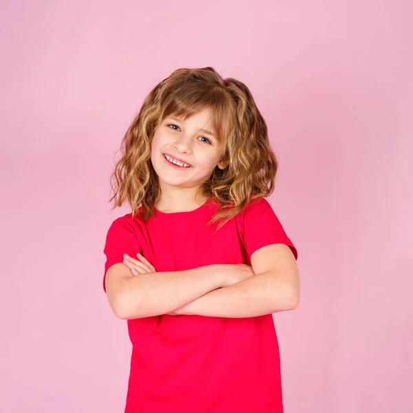 Sød nysgerrig munter lille pige i rød t-shirt Stock-billede