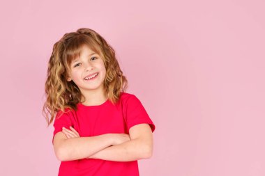 Kırmızı tişörtlü sevimli, meraklı, neşeli küçük kız.
