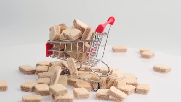 Pilha giratória de biscoitos wafer quadrados e carrinho de compras — Vídeo de Stock