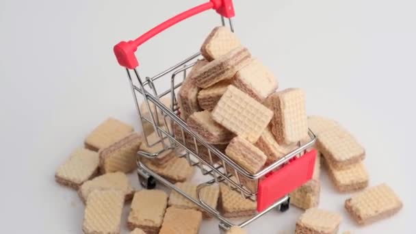 Montón giratorio de galletas de oblea cuadradas y carrito de compras — Vídeo de stock