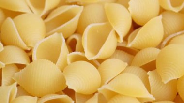 Kuru pişmemiş İtalyan Conchiglie makarnası dönüyor..