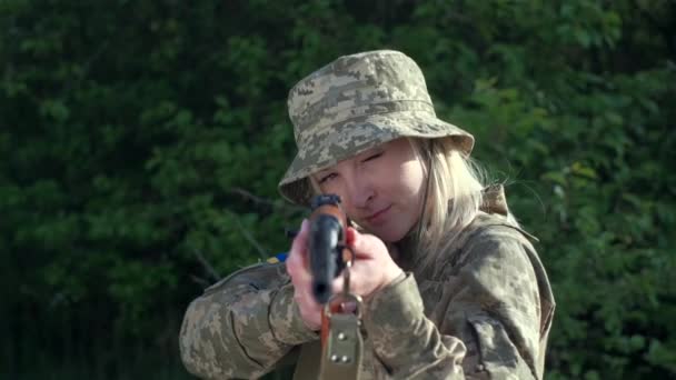 Closeup woman in uniform in zone of armed conflict aims with an assault rifle — Stockvideo