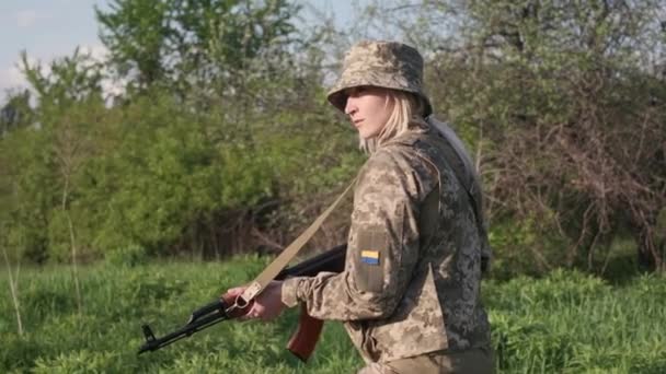 Una soldado ucraniana armada con un rifle de asalto patrulla una zona de combate — Vídeo de stock