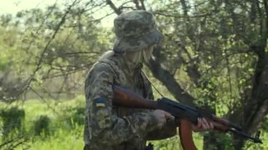 Silahlı Ukraynalı kadın asker saldırı bölgesinde devriye geziyor.