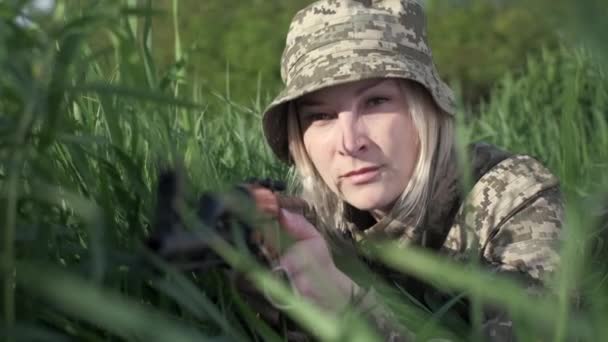 Українська жінка-солдат озброєна штурмовою гвинтівкою, що лежала в траві і цілилася. — стокове відео