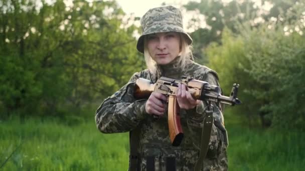 Ukrainian female soldier armed with an assault rifle patrols a combat zone — Stock Video