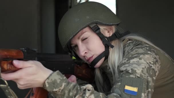 Closeup woman in uniform in zone of armed conflict aims with an assault rifle — Stockvideo