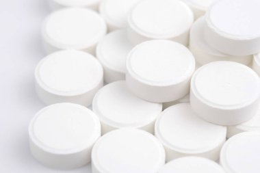 Many white medical pills close up. Pharmaceutical Industry and medicine concept. 