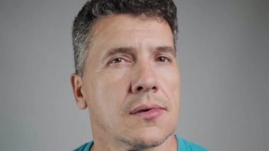 Allergic reaction to a bee sting. An unshaven man is stung by a bee and touches his face. Edema, swelling of the lower lip