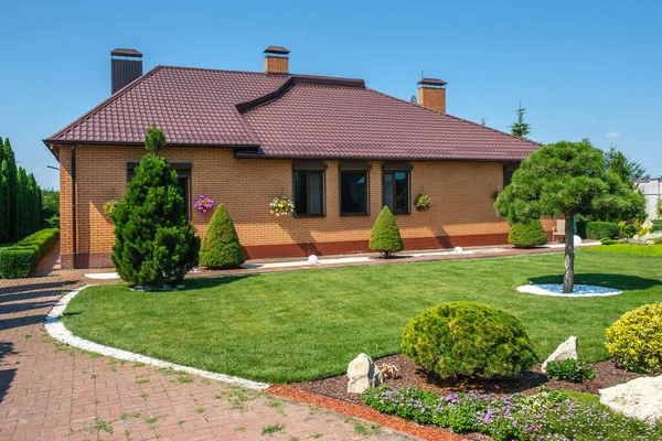 Backyard garden with nicely trimmed bonsai, bushes and stones in front of the European style villa. Landscape design. High quality photo