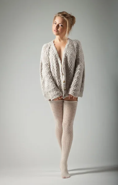 Gyönyörű fiatal nő kötött pulóver-szürke háttér Stock Kép
