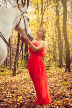 Genç bir kadın atına bakıyor.