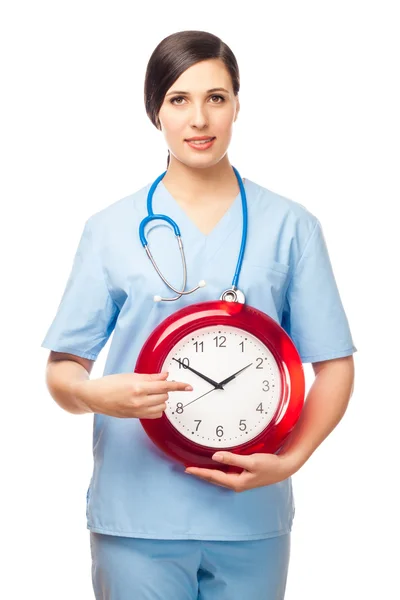 The girl-doctor shows a finger on an alarm clock. — Stock Photo, Image