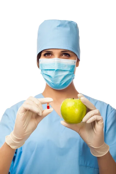 Young doctor holding pill and apple — Stock Photo, Image