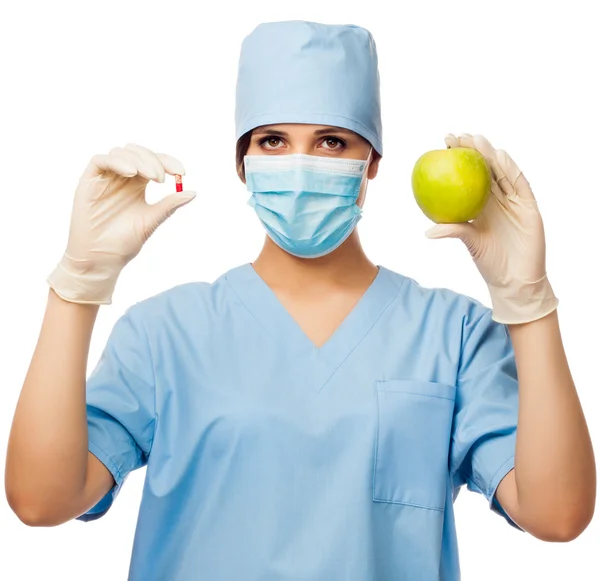 Young doctor holding pill and apple — Stock Photo, Image