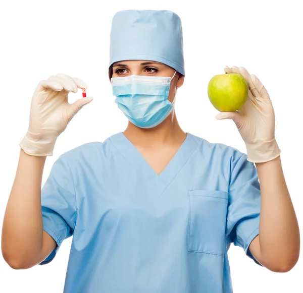 Junge Ärztin mit Pille und Apfel — Stockfoto