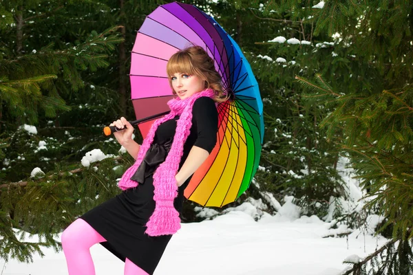 Женщина с цветным зонтиком зимой — стоковое фото