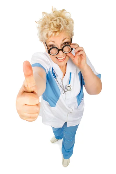 Smiling adult woman doctor shows thumb in camera — Stock Photo, Image