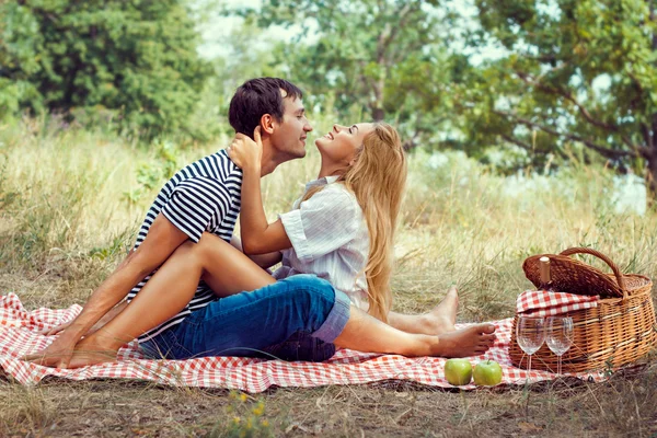 Mladý pár na piknik, sedí tváří na fa — Stock fotografie