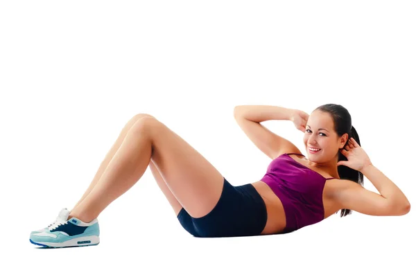 Beautiful woman in sportswear does exercises lying on floor — Stock Photo, Image