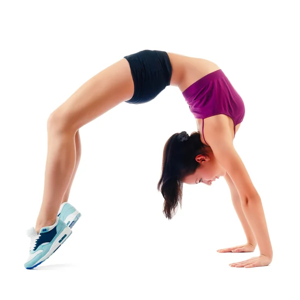 Beautiful woman in sportswear does exercises sitting on floor — Stock Photo, Image