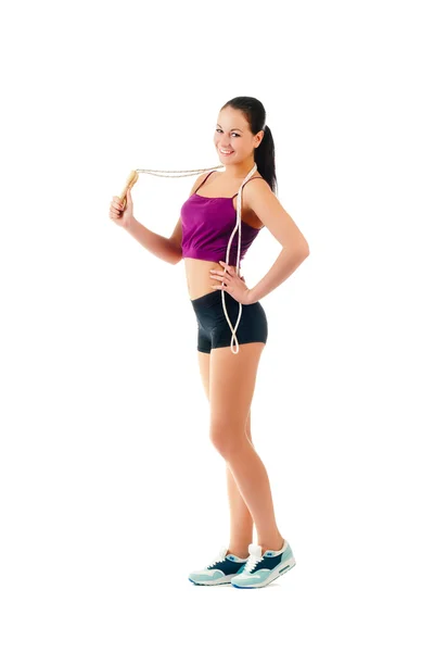 Jonge vrouw met springtouw op schouder staan zijwaarts in sportsw — Stockfoto