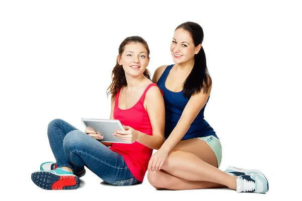 Two young sitting women with pad — Stock Photo, Image