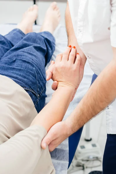 Close-up de um fisioterapeuta que trata um paciente. Osteopata segura uma mão de mulher — Fotografia de Stock