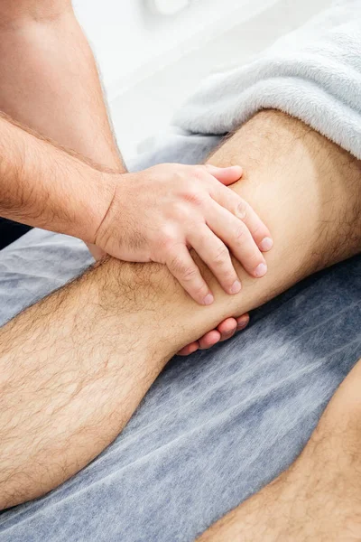 An osteopath examines a mans knee — Stock Photo, Image